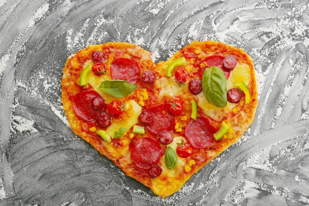 Tasty heart shaped pizza on black flour powdered table — Stock Photo ...