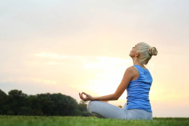 Güzel bir kadın yoga yapıyor. 