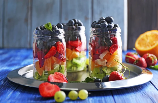 Glass jars with fruits and berries — Stock Photo, Image