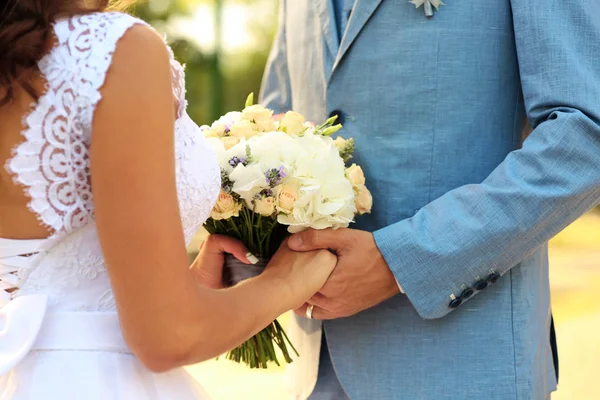 Bruidspaar met boeket van bloemen — Stockfoto