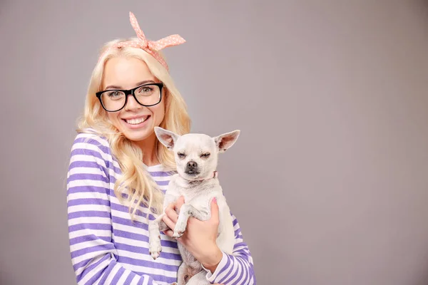 Hermosa chica sosteniendo lindo perro — Foto de Stock