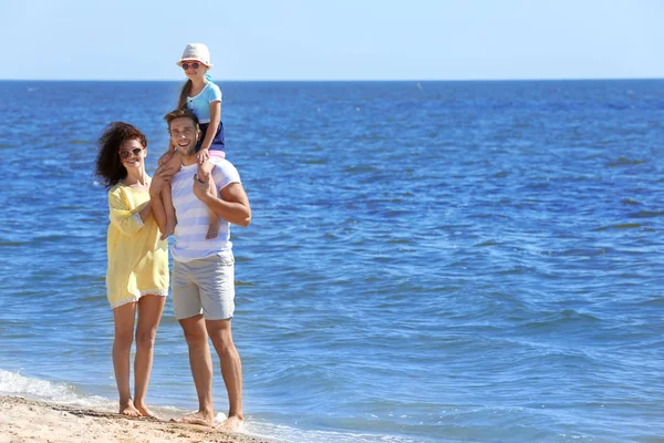 Familienkonzept. Eltern mit Tochter spazieren am Strand — Stockfoto