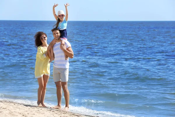 Familienkonzept. Eltern mit Tochter spazieren am Strand — Stockfoto