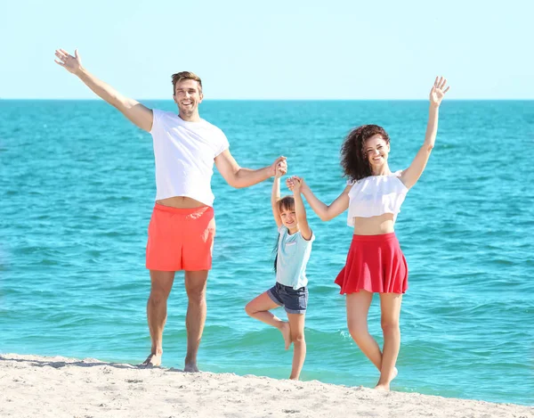 Koncept rodziny. Rodzice i Córka, trzymając się za ręce i stojącą na tle morza — Zdjęcie stockowe