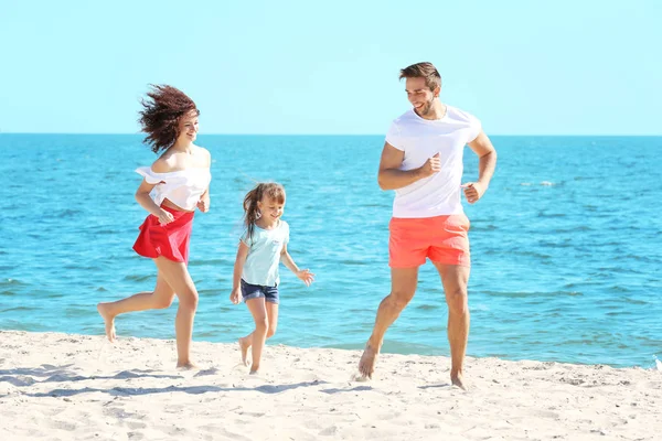 Járműcsalád-koncepció. Boldog szülők és lánya játszik a tengerparton — Stock Fotó