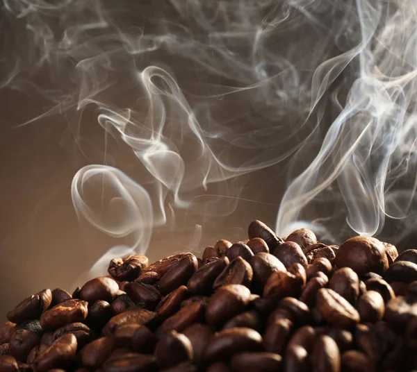 Chicchi di caffè con fumo su sfondo scuro — Foto Stock