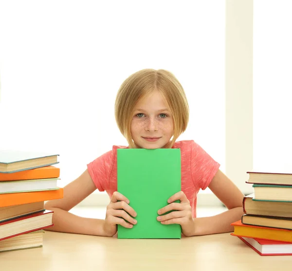 Menina sorridente com muitos livros — Fotografia de Stock