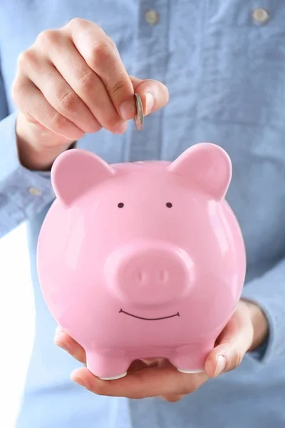 Homem colocando moeda em Piggy Bank — Fotografia de Stock