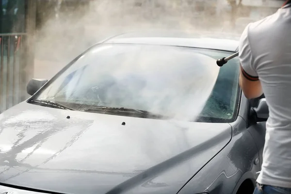 Hombre lavado de coches con agua de alta presión — Foto de Stock