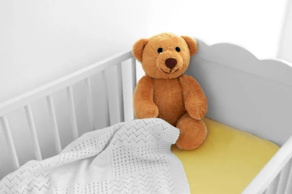 White crib with plaid and cuddly bear — Stock Photo, Image