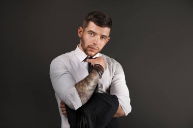 Koyu arka plan üzerinde poz genç dövmeli adam
