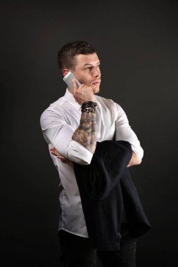 Koyu arka plan üzerinde poz genç dövmeli adam