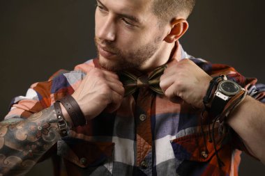 Koyu arka plan üzerinde poz genç dövmeli adam