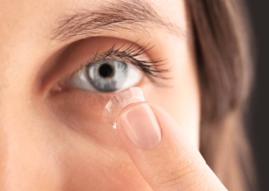 Kontakt lens gözlerinin içine koyarak kadın