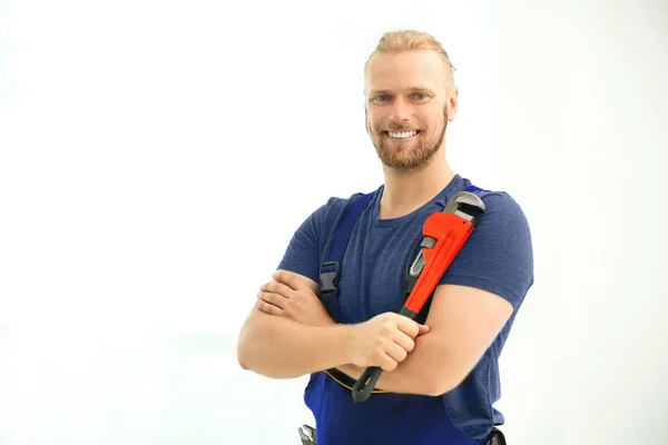 Handsome plumber with pipe wrench — Stock Photo, Image