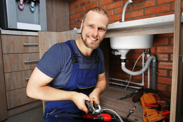 Handsome plumber repairing — Stock Photo, Image