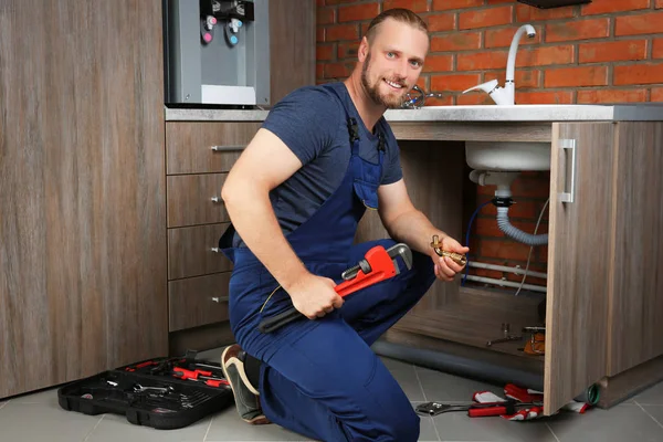 Handsome plumber repairing — Stock Photo, Image