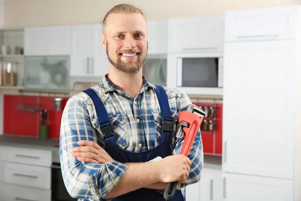 Knappe loodgieter met pipe wrench — Stockfoto