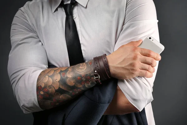 Young tattooed man posing on dark background — Stock Photo, Image