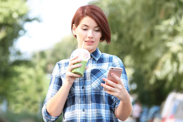 Ung kvinna med grön smoothie — Stockfoto