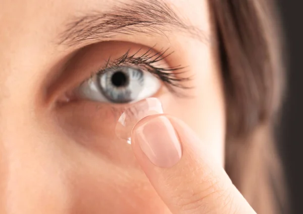Mujer poniendo lente de contacto en el ojo — Foto de Stock