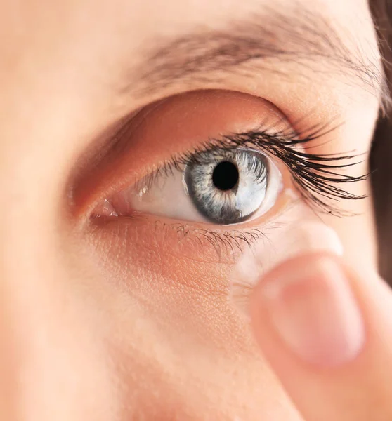 Žena uvedení kontaktní čočky v oku — Stock fotografie