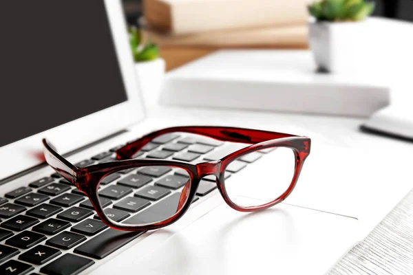 Glasses lying on laptop — Stock Photo, Image