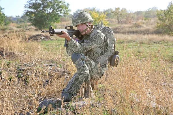 Soldier in camouflage taking aim at military firing range