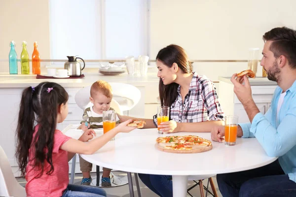 Счастливая семья ест еду на кухне — стоковое фото