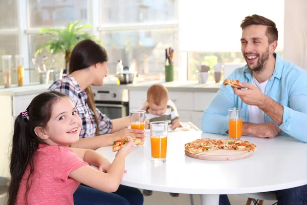 Счастливая семья ест еду на кухне — стоковое фото