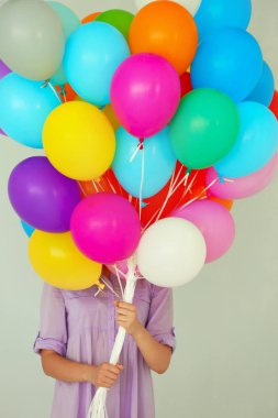 Birçok renkli balon tutan kız