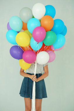Birçok renkli balon tutan kız
