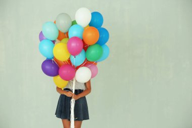 Birçok renkli balon tutan kız