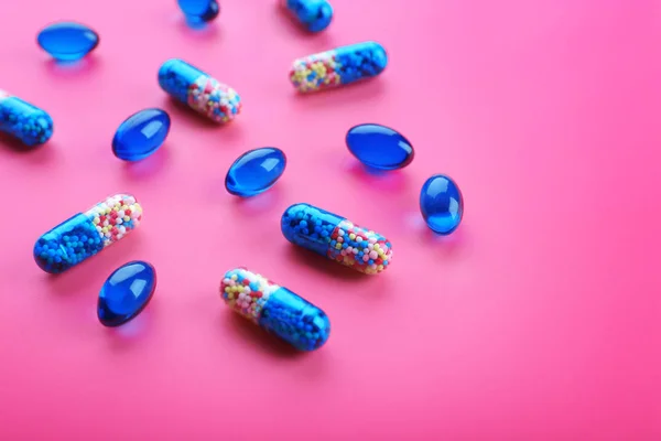 Píldoras de color sobre fondo rosa — Foto de Stock