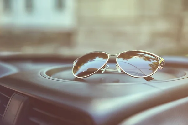 new sunglasses on car panel, close-up