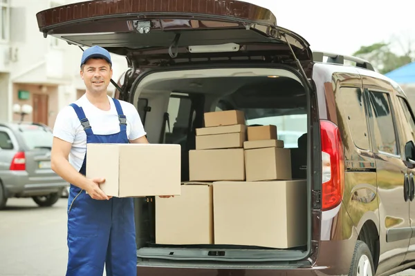 Conceito de entrega. Carteiro com carro — Fotografia de Stock