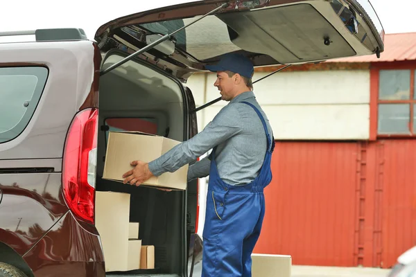 Conceito de entrega. Carteiro com carro — Fotografia de Stock