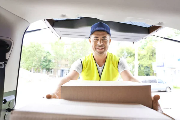 Lieferkonzept. Postbote mit Auto — Stockfoto