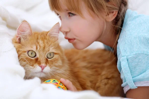 Söpö pieni tyttö ja punainen kissa — kuvapankkivalokuva