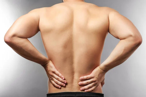 Mann mit Rückenschmerzen auf grau — Stockfoto