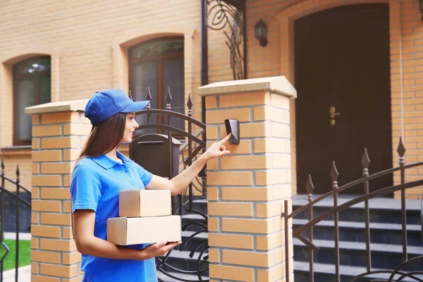 Courrier féminin en uniforme sonnant à la porte — Photo