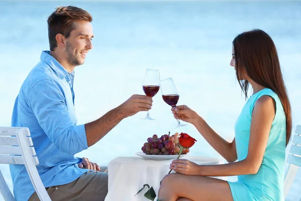 夫妇与葡萄和葡萄酒在海滩上 — 图库照片