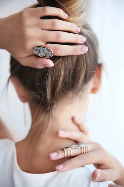 Manos femeninas en la cabeza con anillos elegantes — Foto de Stock