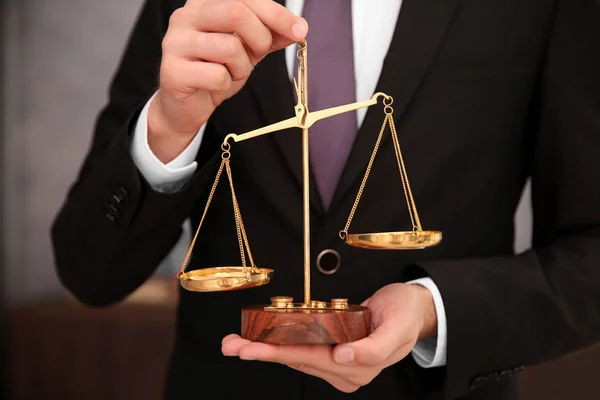 Руки адвоката, держащего судебные весы — стоковое фото