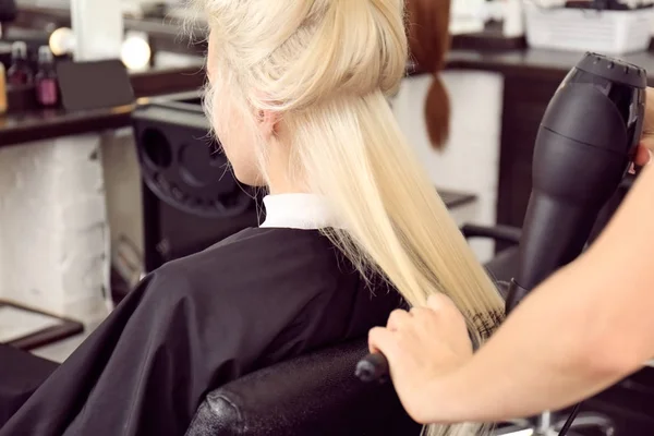 Hairdresser drying blonde's hair — Stock Photo, Image
