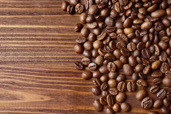 Grãos de café na mesa de madeira — Fotografia de Stock