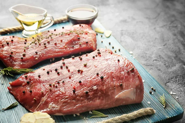 Tasty steaks with marinade ingredients — Stock Photo, Image