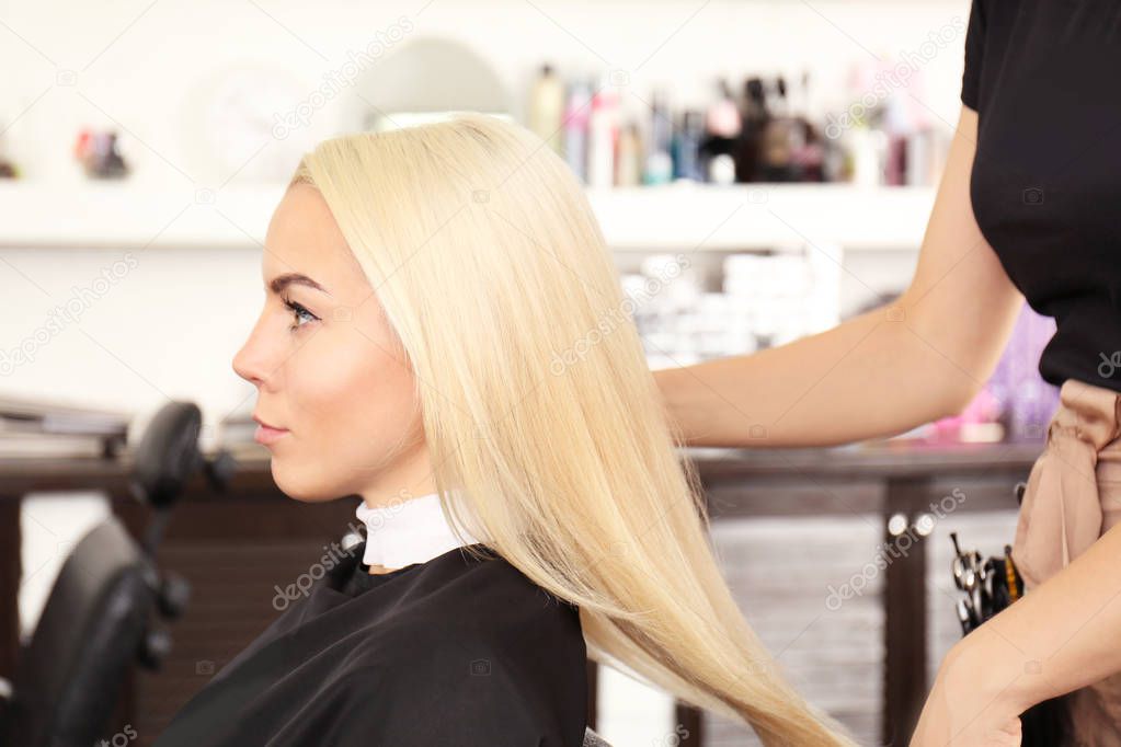 Hairdresser drying blonde's hair