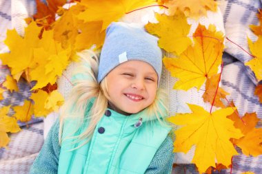 Sonbahar parkında küçük şirin bir kız.