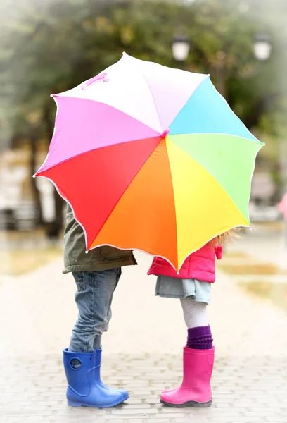 Дети прячутся за зонтиком — стоковое фото
